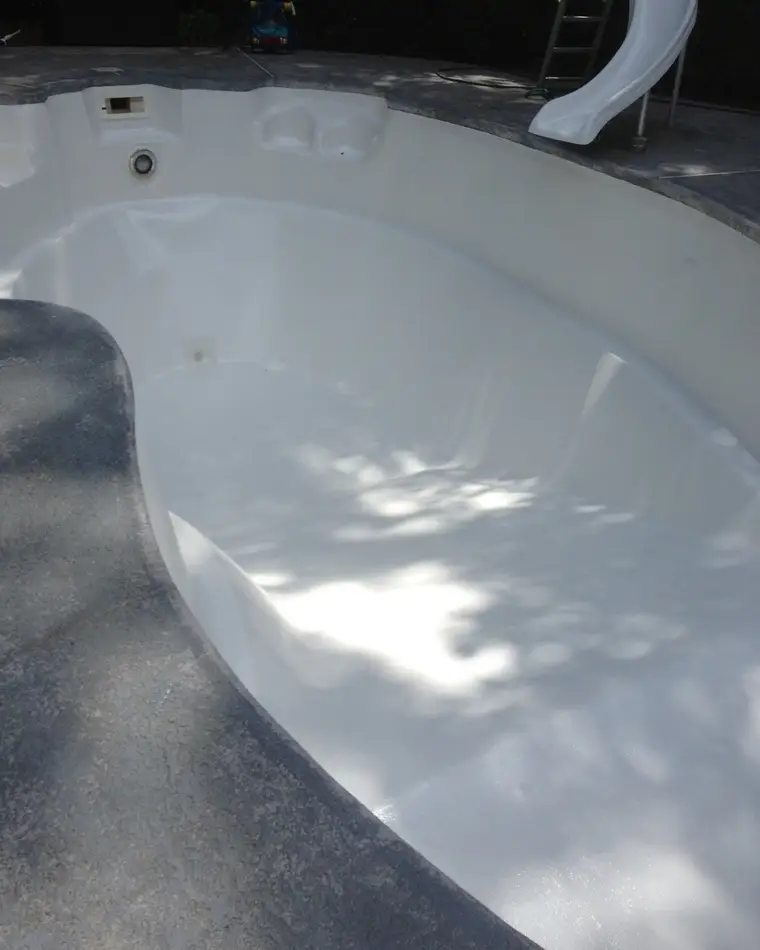 The same fiberglass pool shell after refinishing, re-coated to a smooth even white.
