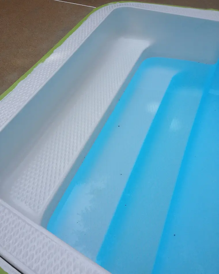 The same spa step unit after repair and refinishing, re-coated to a clean white.