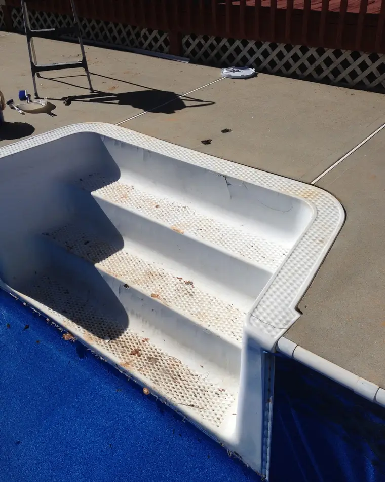Pool steps before refinishing, with rust-coloured staining running down every tread.