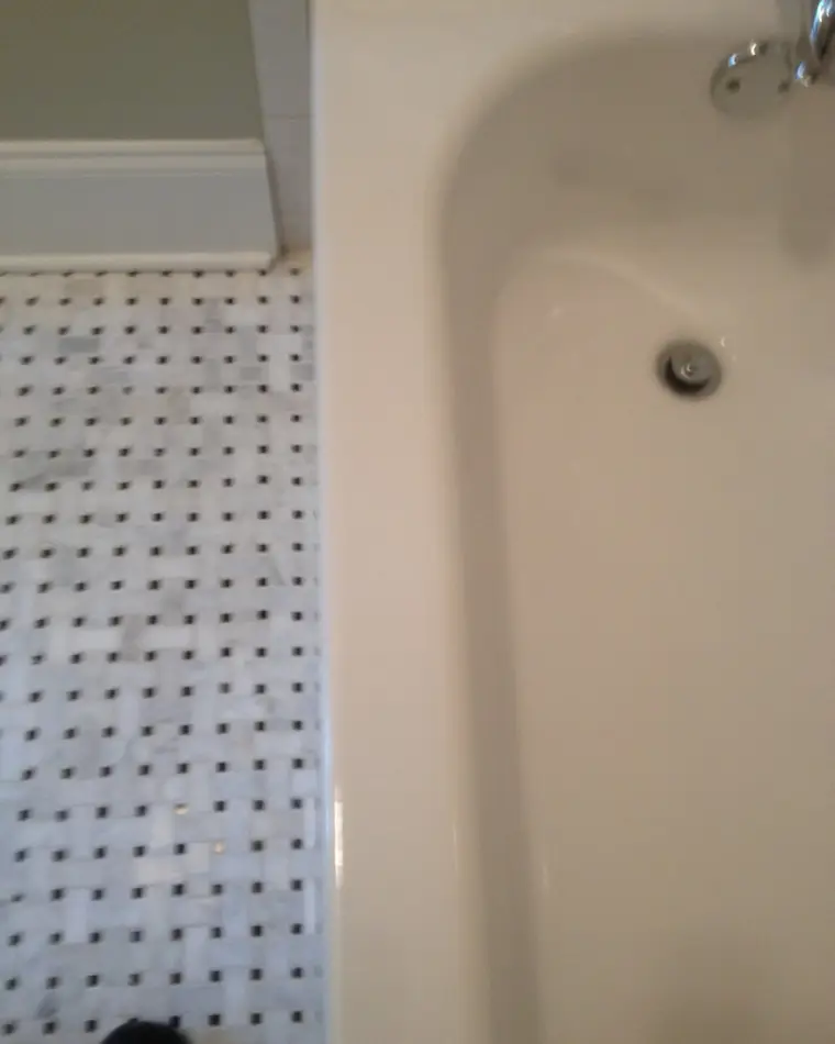 The same bathtub apron after repair, the chip filled and blended into the surrounding finish.